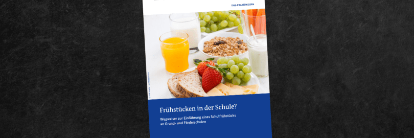 Schwarze Tafel mit einem lilafarbenen Magnet an dem Titelblatt der DGE-Broschüre